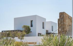 a white house with a stone chimney at Omvrodektis Village in Mykonos Airport