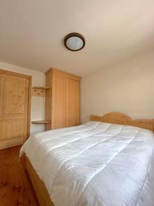 a bedroom with a large white bed with a ceiling at Chalet del Borgo in Le Bratte