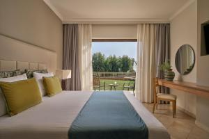 a bedroom with a large bed and a large window at Lindos Imperial Resort & Spa in Kiotari +56 photos