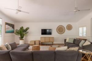 a living room with couches and a flat screen tv at Sunrise Guesthouse in Byron Bay