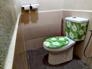 a bathroom with a toilet with a green lid at 4F Motel and Homestay by LTS in Pantai Cenang +23 photos