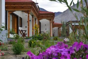 a row of buildings with flowers in the foreground at The Walnut Inn Resort in Hundar