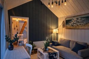 a living room with a couch and a table at Berzkrasti Lake House with Private Sauna & Beach in Sigulda