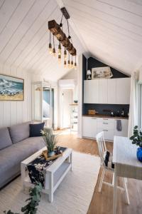 a living room with a couch and a table at Berzkrasti Lake House with Private Sauna & Beach in Sigulda