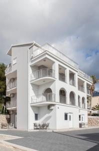 - un bâtiment blanc avec des balcons sur le côté dans l'établissement Villa Klara Guest House, à Baška Voda