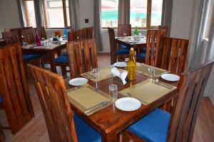 a restaurant with wooden tables and chairs with a bottle of wine at The Walnut Inn Resort in Hundar