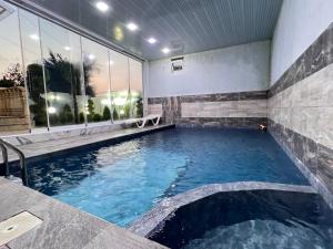 a swimming pool in a building with a large window at Rest House İsmayıllı Villa in İsmayıllı