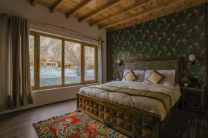 a bedroom with a bed and a large window at The Walnut Inn Resort in Hundar