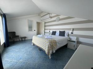 a bedroom with a bed with a striped wall at Hotel La Fontana in Stresa +136 photos