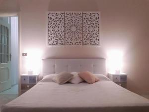 a bedroom with a white bed with two pillows on it at Residenza Villa Gorìa in Pontestura