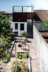 a house with a balcony with a table and chairs at Porta 29 in Vila Franca do Campo