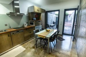 a kitchen with a table and chairs in a room at Porta 29 in Vila Franca do Campo