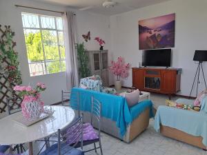 a living room with a couch and a table at Belle maison in Goodlands
