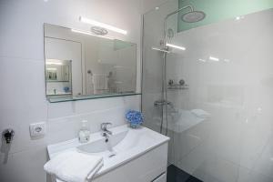 a white bathroom with a sink and a shower at Porta 29 in Vila Franca do Campo +24 photos