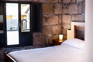a bedroom with a bed and a brick wall at Porta 29 in Vila Franca do Campo