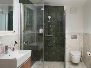 a bathroom with a shower with a toilet and a sink at Numa Stuttgart Rotebühlplatz in Stuttgart