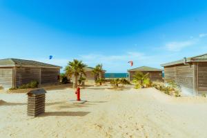 a red fire hydrant in the middle of a beach at Oasis212 Dakhla in Dakhla