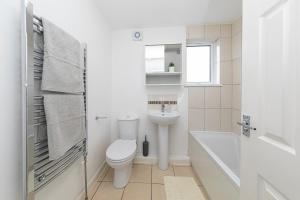 a white bathroom with a toilet and a sink at The Cosy Durham Nest in Langley Park