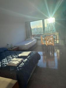 a room with two beds and a table and chairs at APART CyJ OBELISCO in Buenos Aires