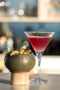 a drink in a glass sitting next to a vase at Searocks Exclusive Village in Kalamata