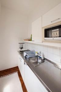 a white kitchen with a sink and a microwave at Mondial Appartement Hotel in Vienna +32 photos