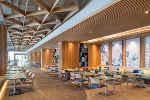 a dining room with tables and chairs and windows at OZO North Pattaya in Pattaya