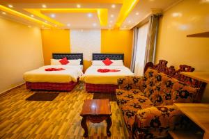 a hotel room with two beds and a couch at Amboseli Gateway Hotel in Kimana +21 photos