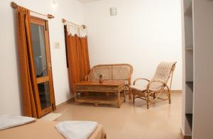 a living room with a table and two chairs at The Mountain Retreat in Tiruvannāmalai +20 photos