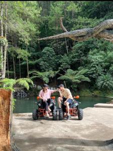 two men are riding on four wheelers by a river at HOUSEBOAT AFFA grup in Karanganyar