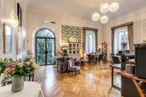 a large room with tables and chairs and a room with windows at Mangili Garden Hotel in Rome