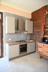 a kitchen with white cabinets and a stove top oven at Ca' Tra Cielo e Monti in Frassinoro