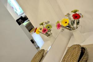 ein Zimmer mit zwei Stühlen mit Blumen im Spiegel in der Unterkunft Ferienwohnung im Univiertel mit Garten in Graz