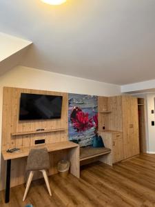 a living room with a television and wooden cabinets at Hotel-Restaurant Hirsch in Berghaupten