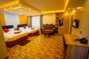 a hotel room with two beds and a television at Amboseli Gateway Hotel in Kimana