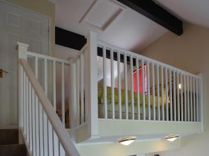 a white staircase with a crib in a room at Puffin Cottage in Wroxham