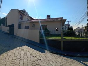 a house with a fence in front of a street at Casa 4 Quartos garagem 3 carros, churrasqueira e ar condicionado, in São José