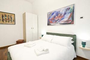 a bedroom with a white bed and a painting on the wall at Top Living Apartments - De Lellis Torino Centro in Turin
