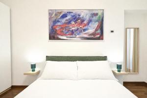 a bedroom with a white bed and a painting on the wall at Top Living Apartments - De Lellis Torino Centro in Turin
