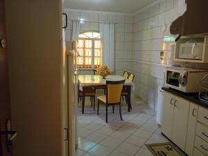 a kitchen with a table and a dining room at Casa 4 Quartos garagem 3 carros, churrasqueira e ar condicionado, in São José
