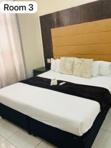 a bedroom with a large bed with white sheets and pillows at The Bright Guest House in Pretoria