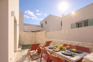 a patio with a table and chairs on a building at Sugarwhite Suites with Private not Heated Pool in Emporio
