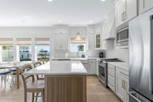 a kitchen with white cabinets and a table with chairs at 26 Blue Coast Ct in Inlet Beach