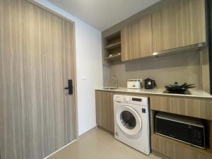 a kitchen with a washer and dryer in a room at Rest&Rise Phuket in Ban Rangeng