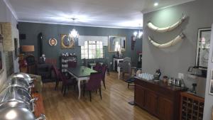 a living room with a table and a dining room at Wayside Lodge in Waterval Boven
