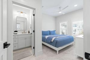 a white bedroom with a blue bed and a sink at 26 Blue Coast Ct in Inlet Beach +49 photos