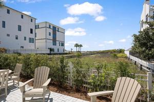 a group of chairs sitting on a patio next to a building at 26 Blue Coast Ct in Inlet Beach