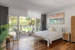 a bedroom with a bed and a balcony at Sunrise Guesthouse in Byron Bay