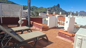 a balcony with a table and chairs on a roof at El Fraile in Tejeda +14 photos
