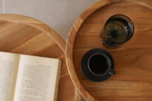 a cup of coffee and a book on a wooden table at Sugarwhite Suites with Private not Heated Pool in Emporio