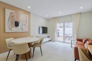 a living room with a table and chairs and a television at Setúbal Serenity Villa I, By Home Match in Setúbal